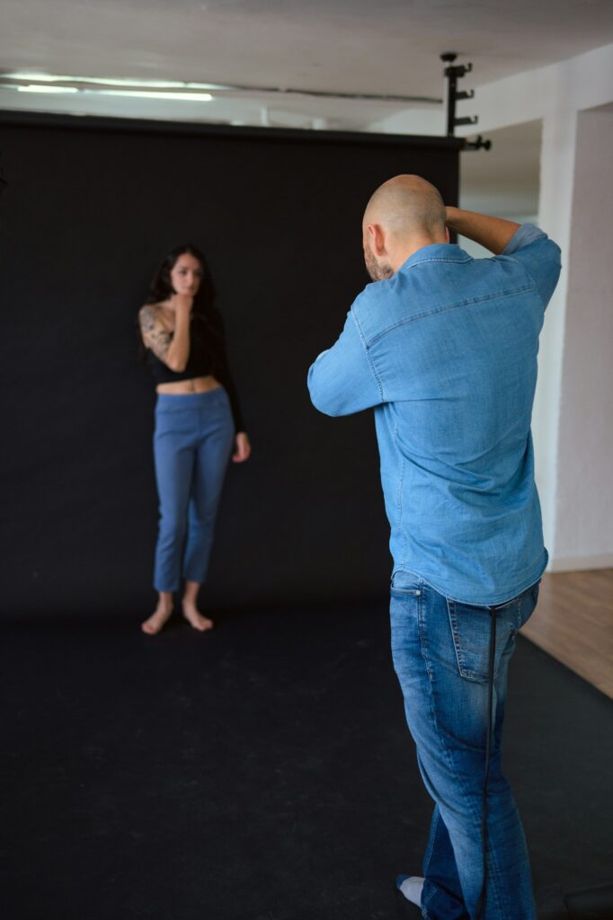 Photographer shooting a model in a studio with a softbox