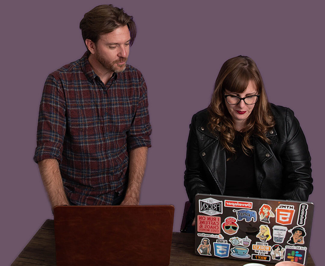 Two professionals working together on a laptop.