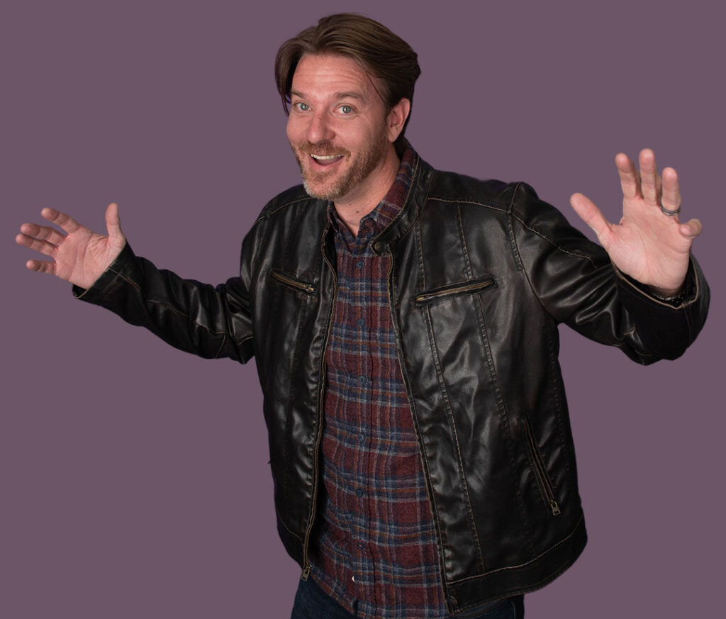 Man in leather jacket smiling with arms raised