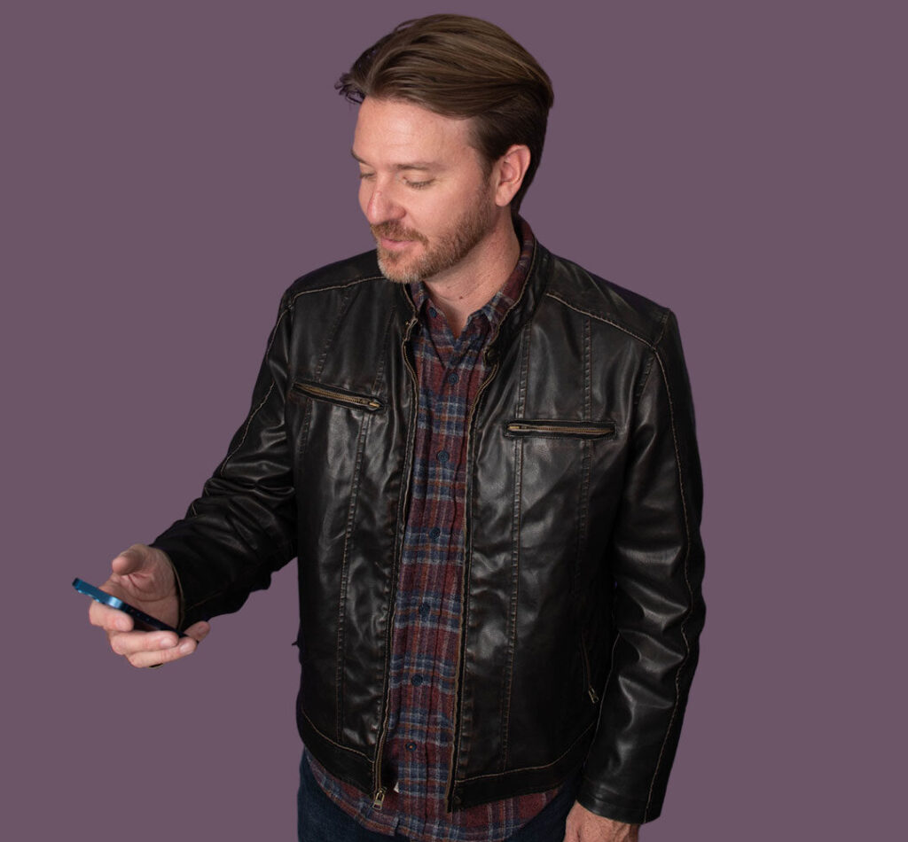 Man in leather jacket looking at smartphone