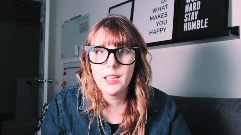 Woman in glasses with motivational posters behind her