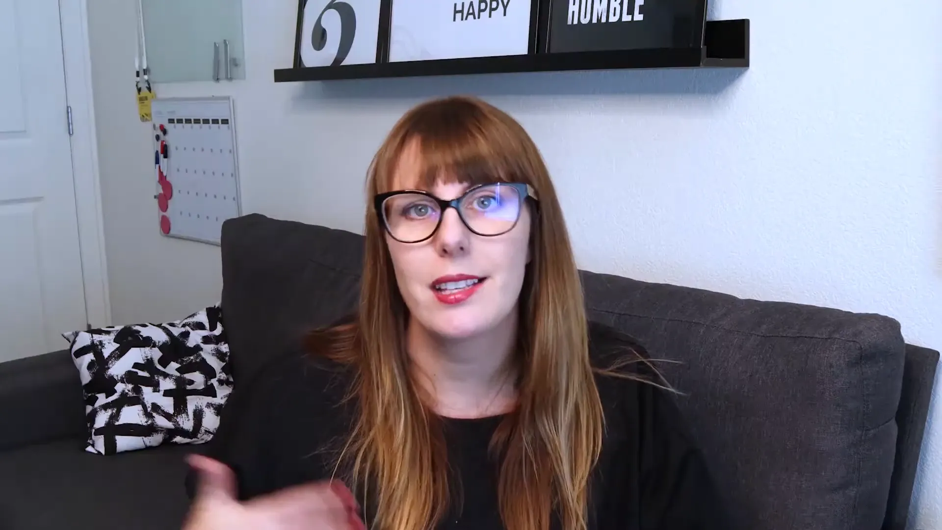 Woman with glasses sitting on couch talking