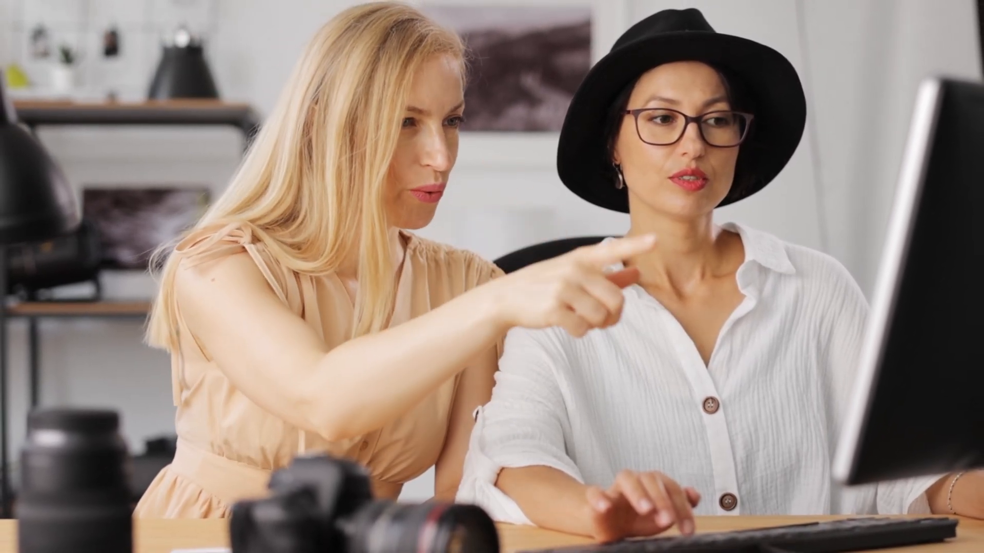 Two women collaborating on a project at computer